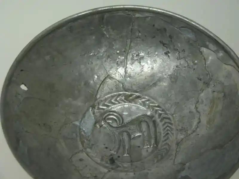 A metal dish with an antelope inside a circle